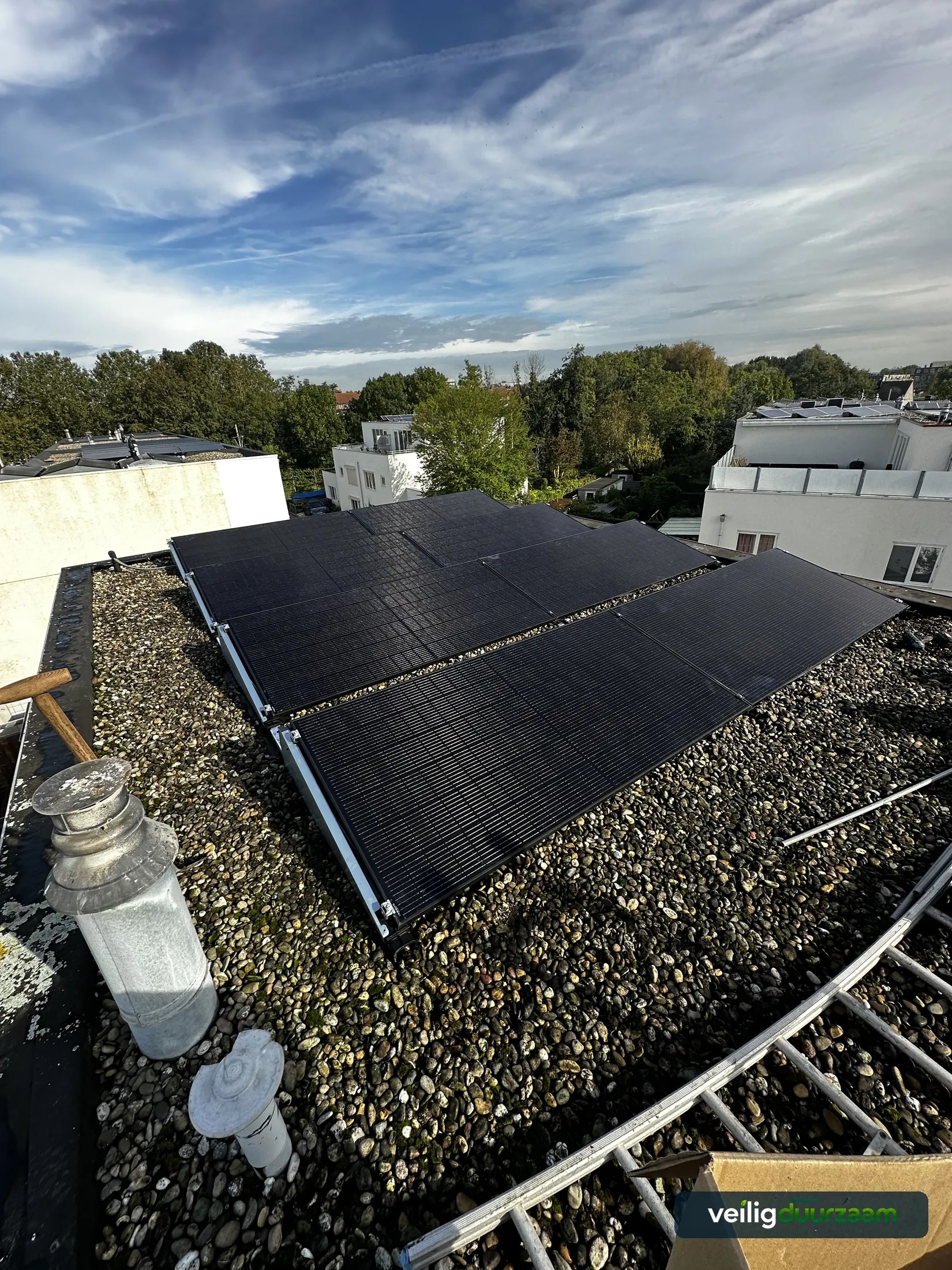 Overzicht van de zonnepaneleninstallatie op een plat dak in Delft