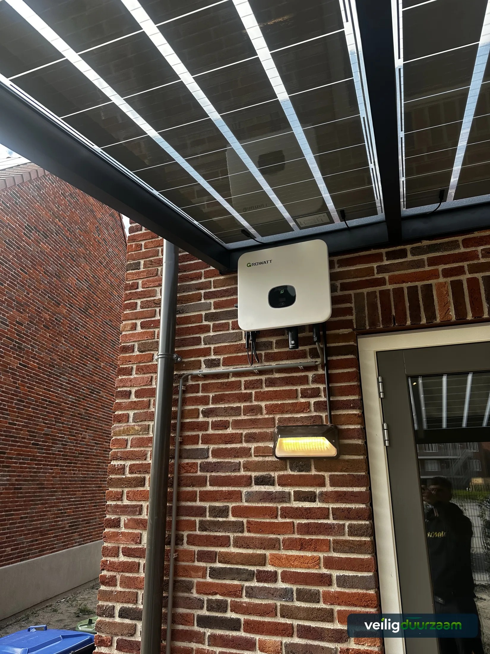 Detail van de Growatt-installatie onder een zonneoverkapping